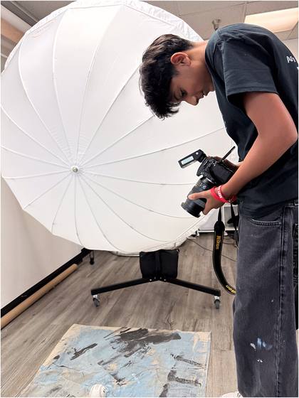 Campers working with a studio light and umbrella