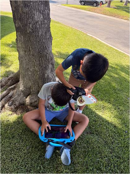 Campers photographing outside under a tree