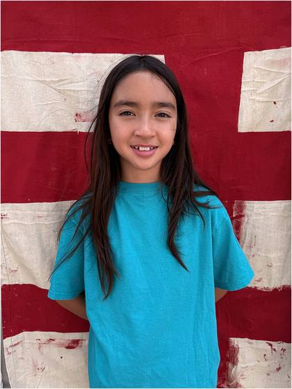 Camper standing in front of the canvas backdrop they painted