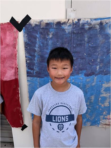 Camper standing in front of the backdrop they painted