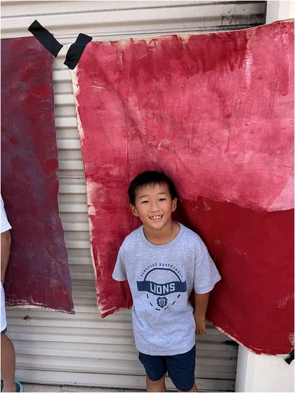 Camper standing in front of the canvas backdrop they painted