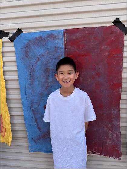 Camper standing in front of a painted canvas backdrop