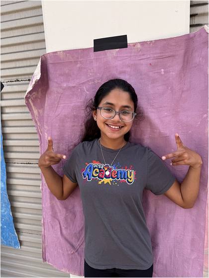Camper standing in front of the canvas backdrop they painted