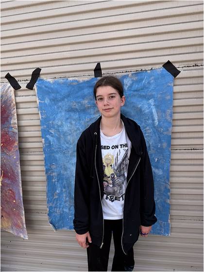 Camper standing in front of the canvas backdrop they painted