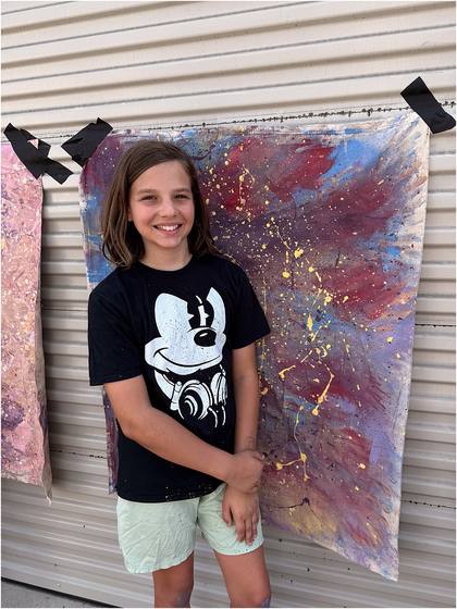 Camper standing in front of the canvas backdrop they painted