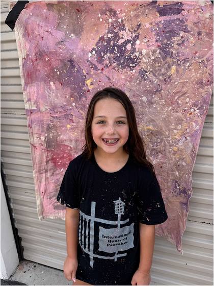 Camper standing in front of the canvas backdrop they painted